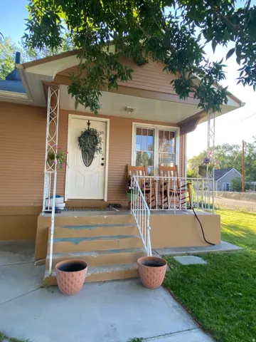 Property entrance with a porch and a lawn