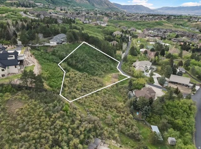 Aerial view of residential area featuring property parcel outlined and mountains