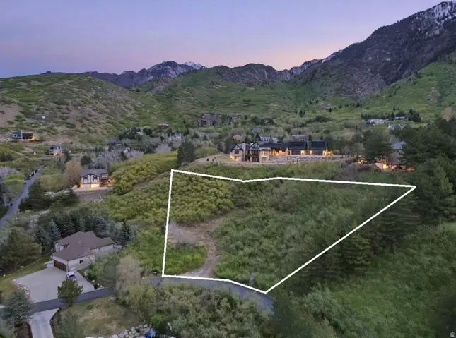 Aerial overview of property's location with a mountain backdrop and property parcel outlined