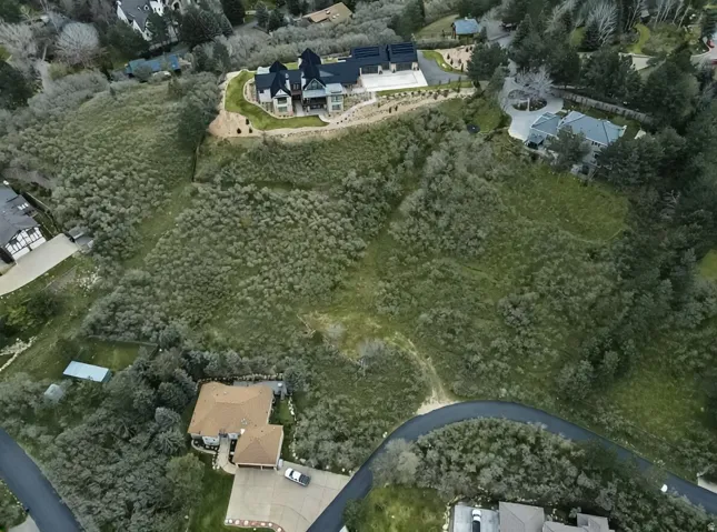 Aerial view of property and surrounding area featuring nearby suburban area