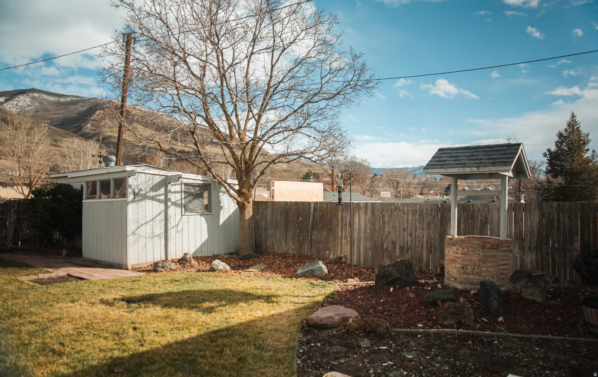 Fenced backyard with an outbuilding and a mountain view
