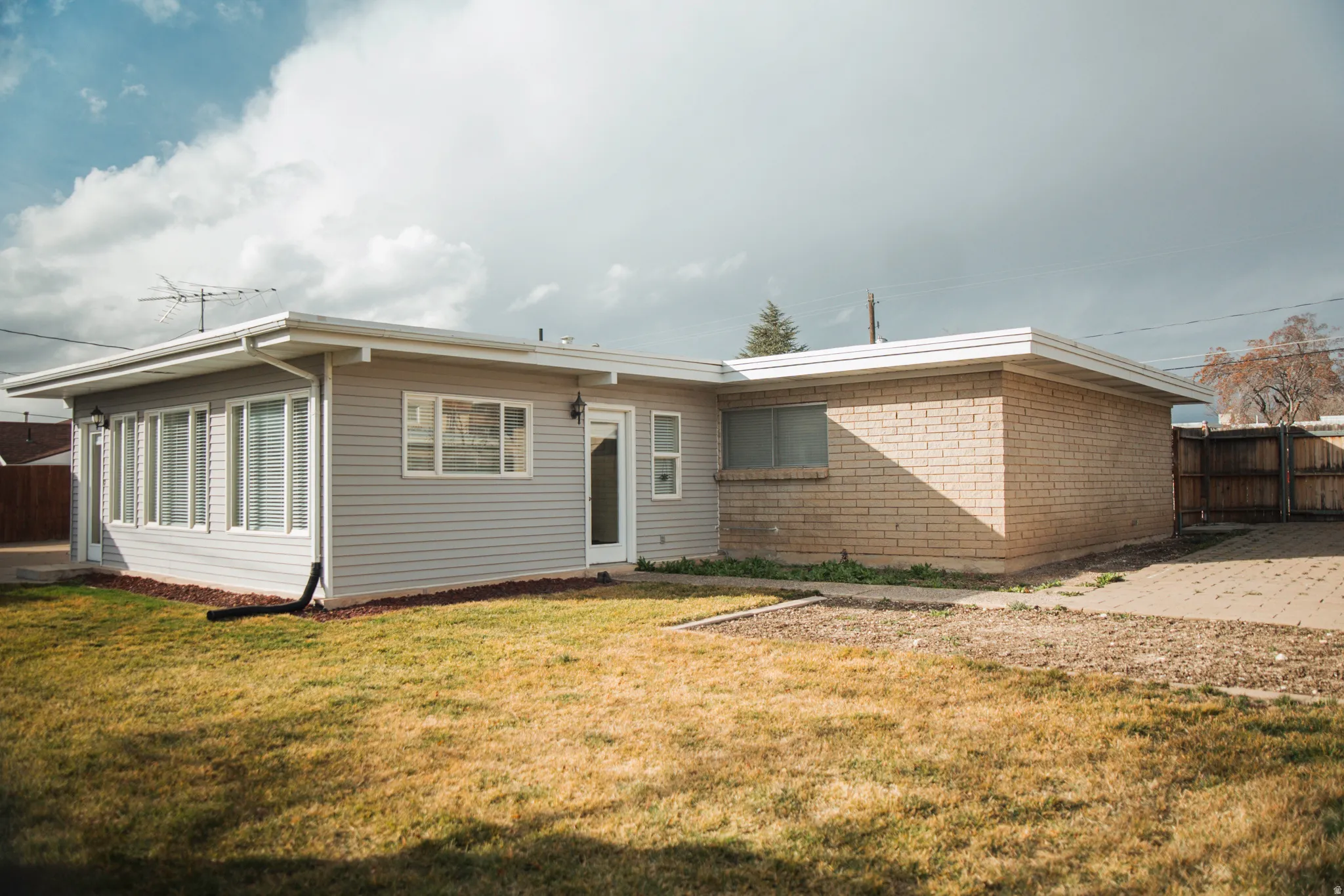 Rear view of property featuring brick masonry and aluminum siding.