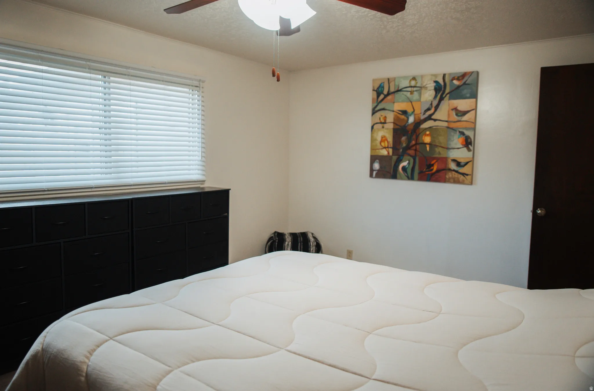 Bedroom with a textured ceiling and a ceiling fan