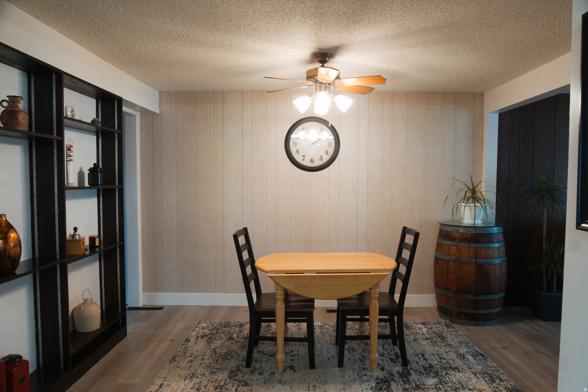 Dining area with ceiling fan, a textured ceiling, and LVP flooring,