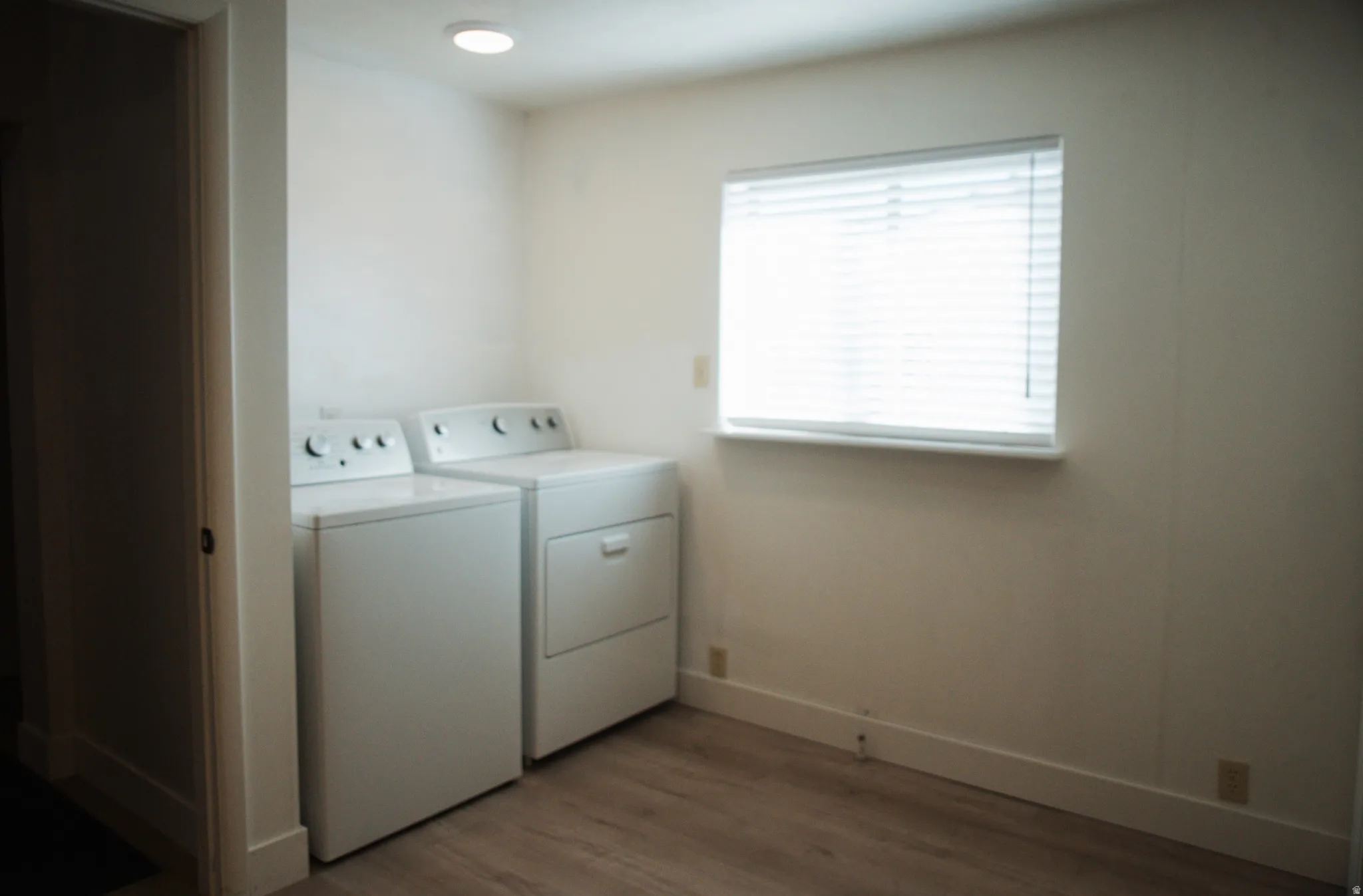 Laundry area with LVP flooring and washer and dryer