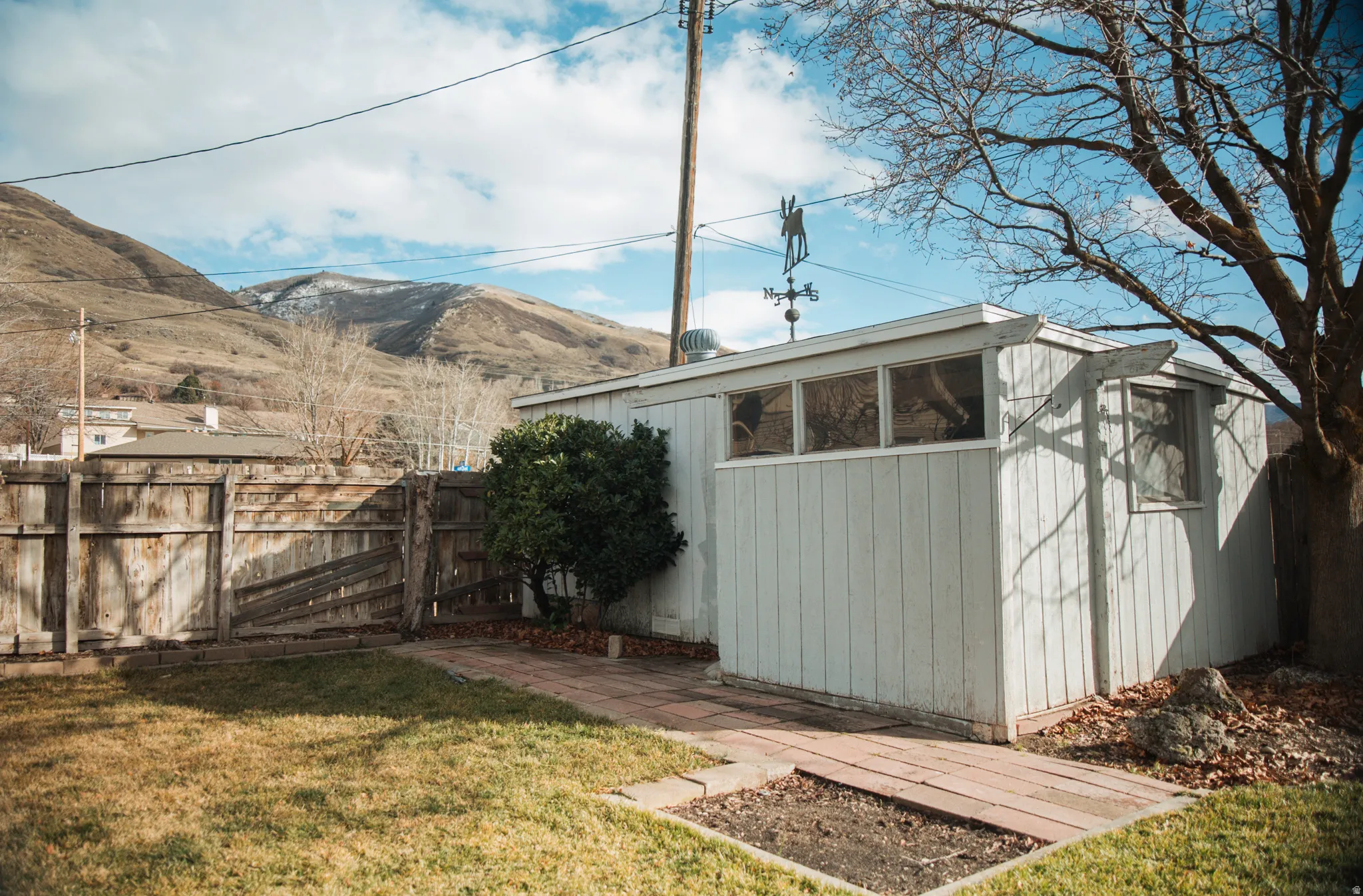 Shed featuring a fenced backyard and a mountain view