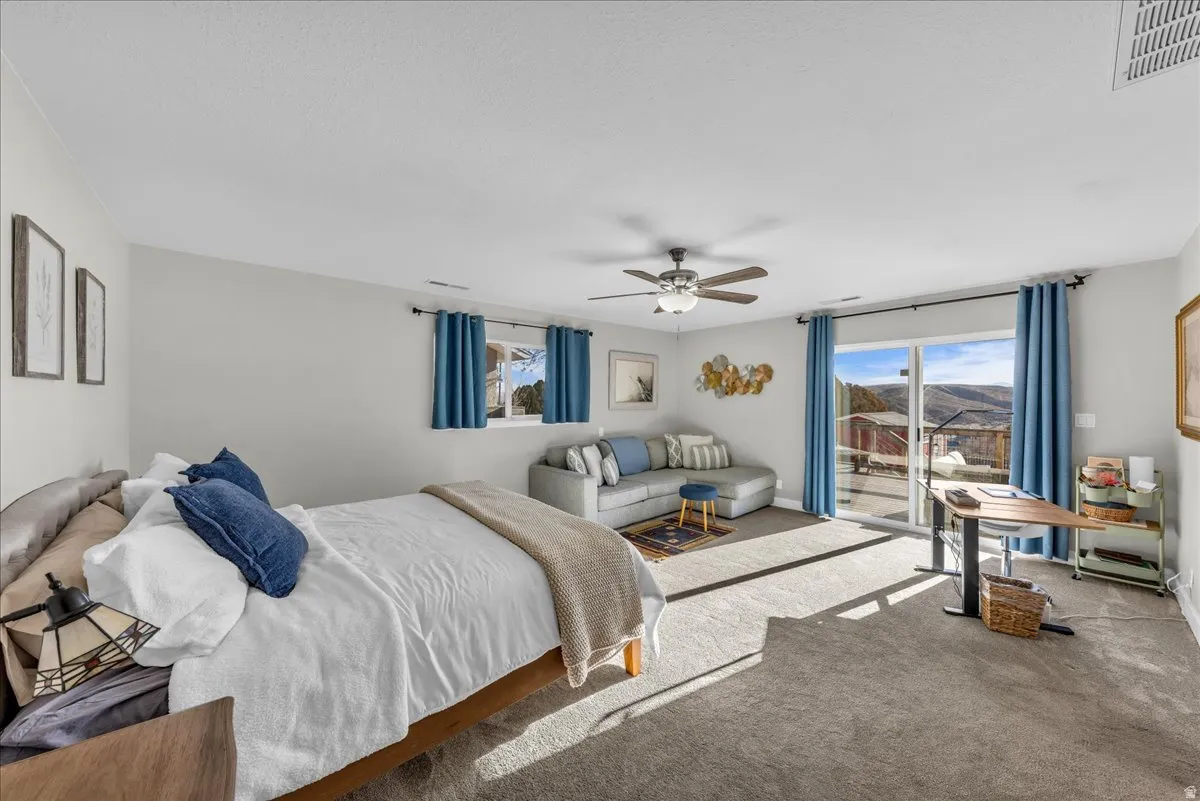 Bedroom featuring carpet, ceiling fan, and access to exterior