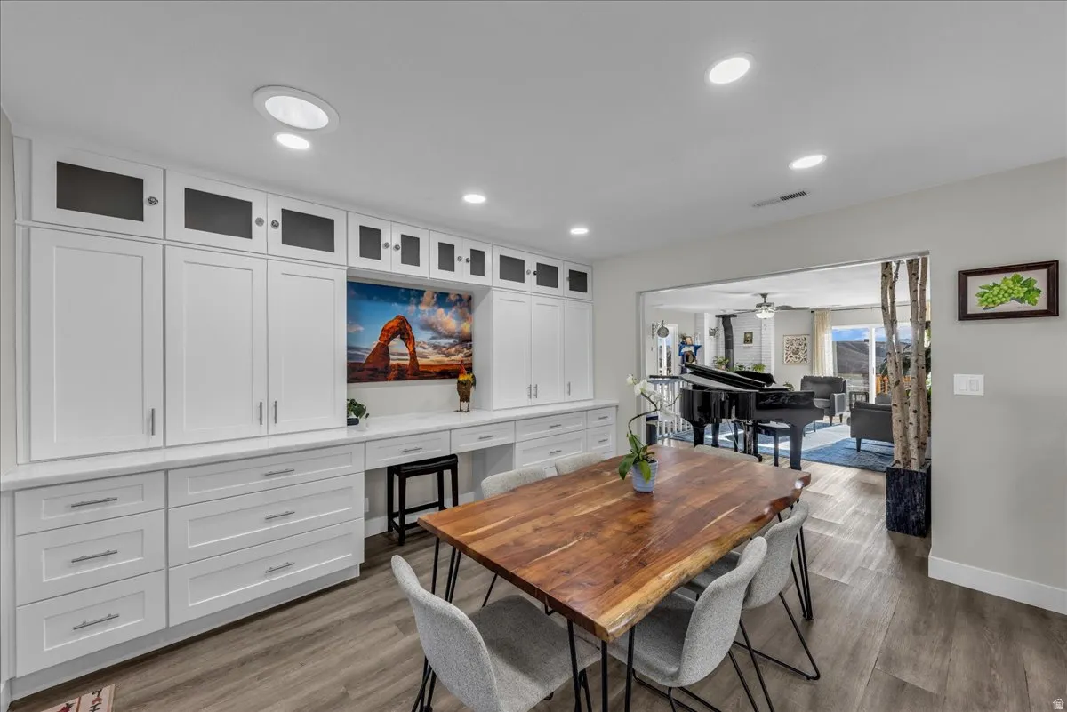 Dining room featuring dark wood-style flooring, recessed lighting, built in study area, and ceiling fan