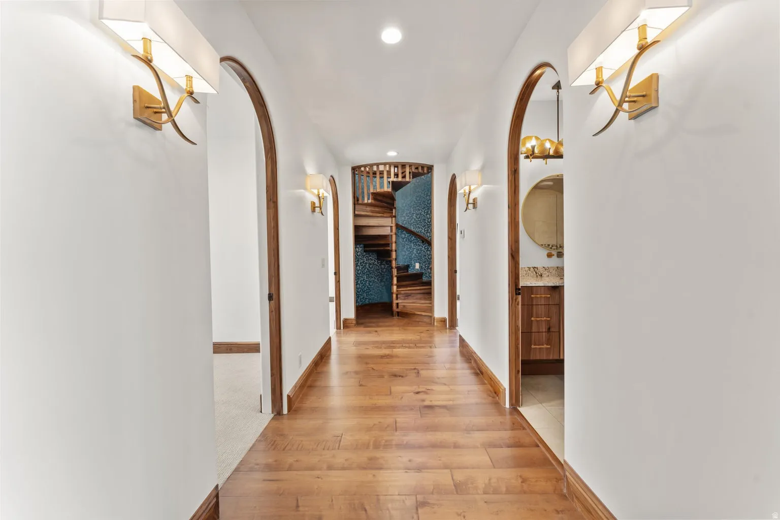 Hallway to 2nd Primary Owner Suite featuring arched walkways, recessed lighting, and light wood-style floors