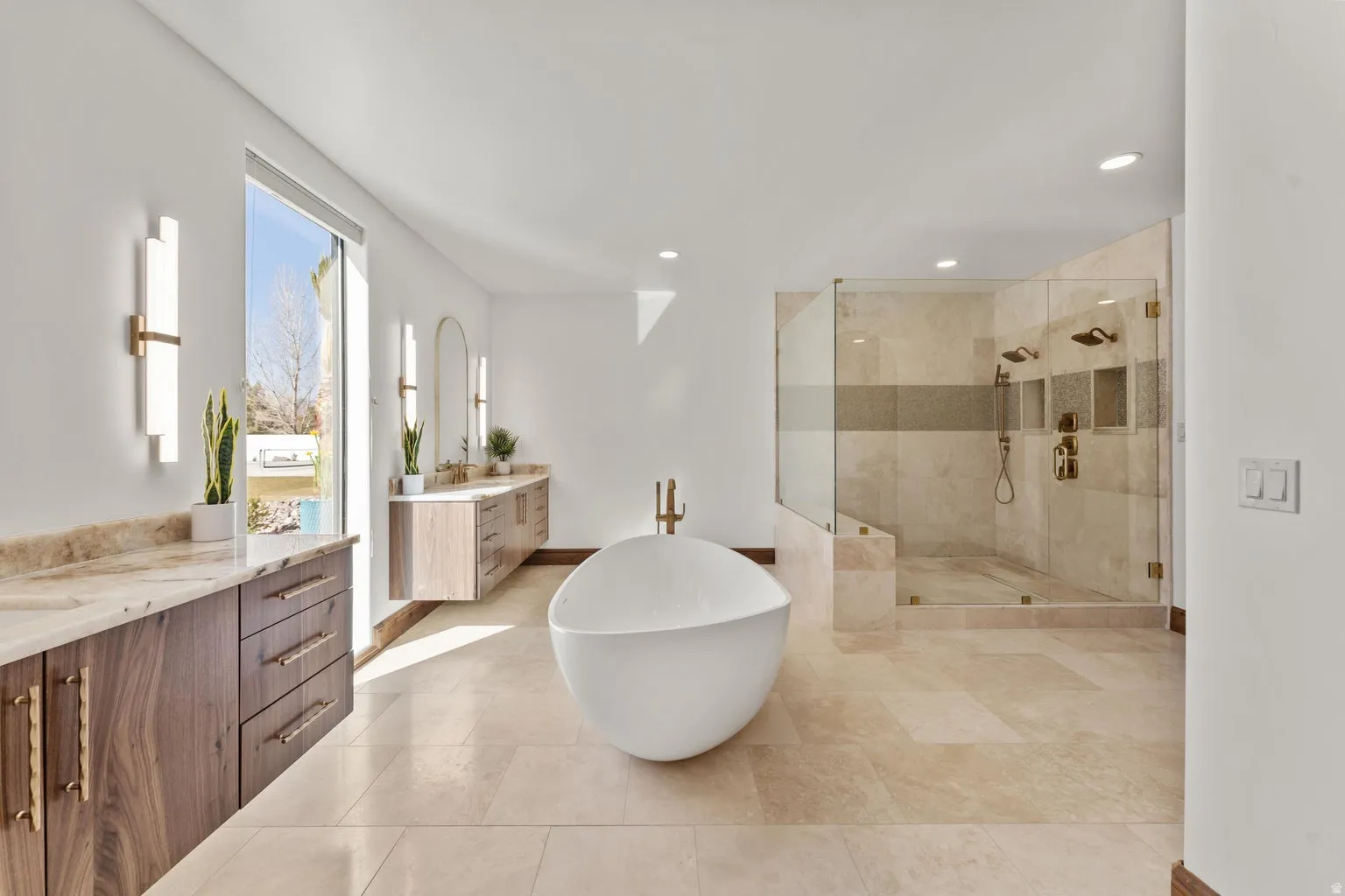 Primary Owner Bathroom featuring a stall shower, two vanities, a soaking tub, and recessed lighting