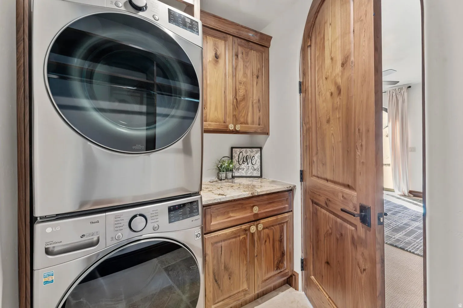 2nd Primary Owner Suite Laundry area with cabinet space and stacked washing machine and dryer