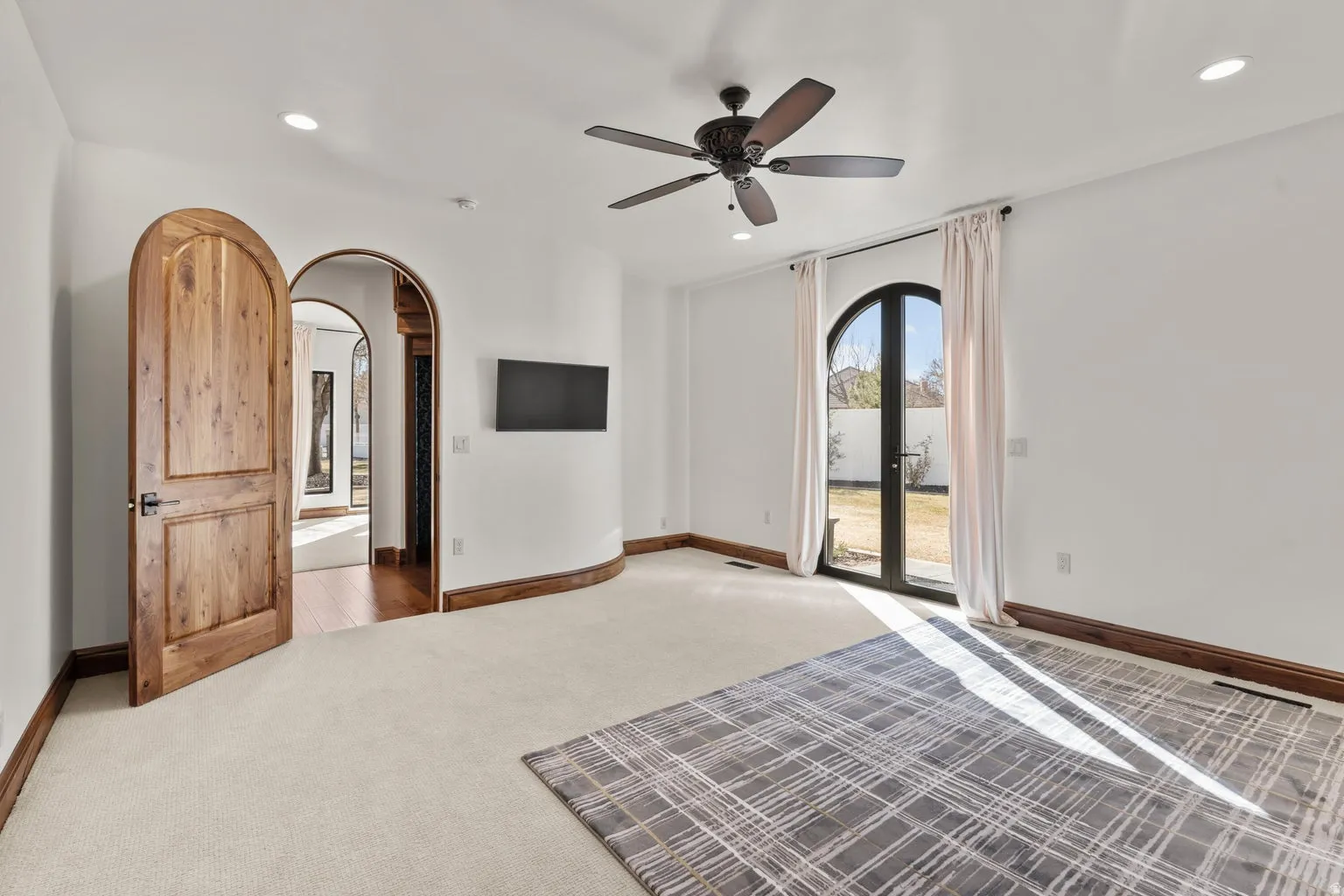 2nd Primary Owner Suite with arched walkways, carpet floors, access to exterior, a ceiling fan, and recessed lighting