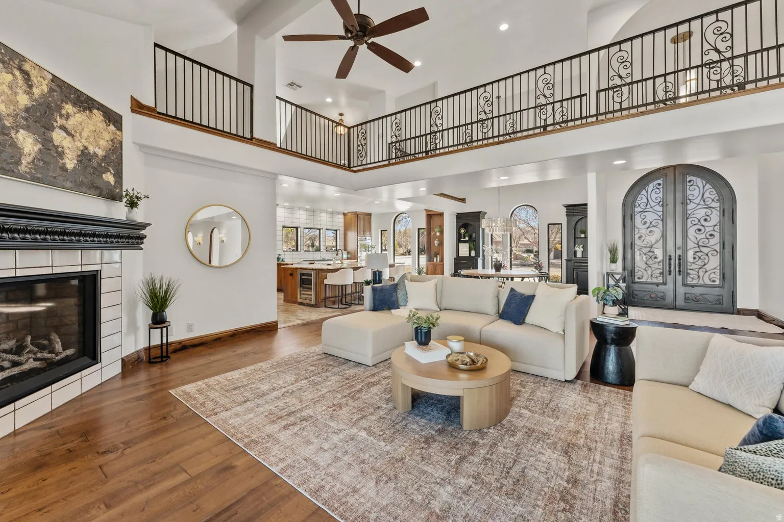 Living room featuring a glass covered fireplace, wood-type flooring, a ceiling fan, french doors, and arched walkways