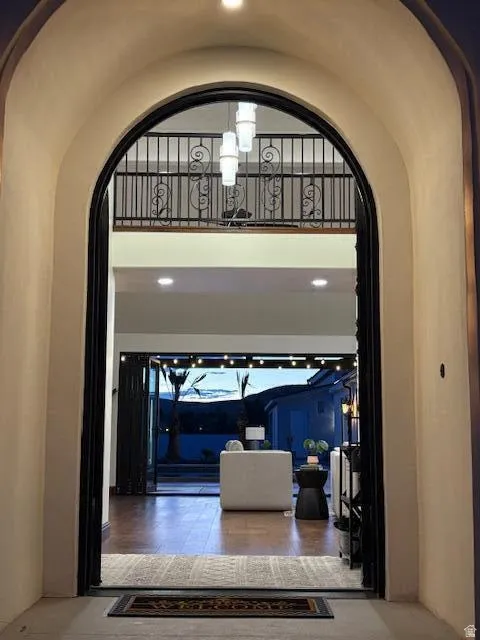 Hall featuring arched walkways, a high ceiling, and recessed lighting