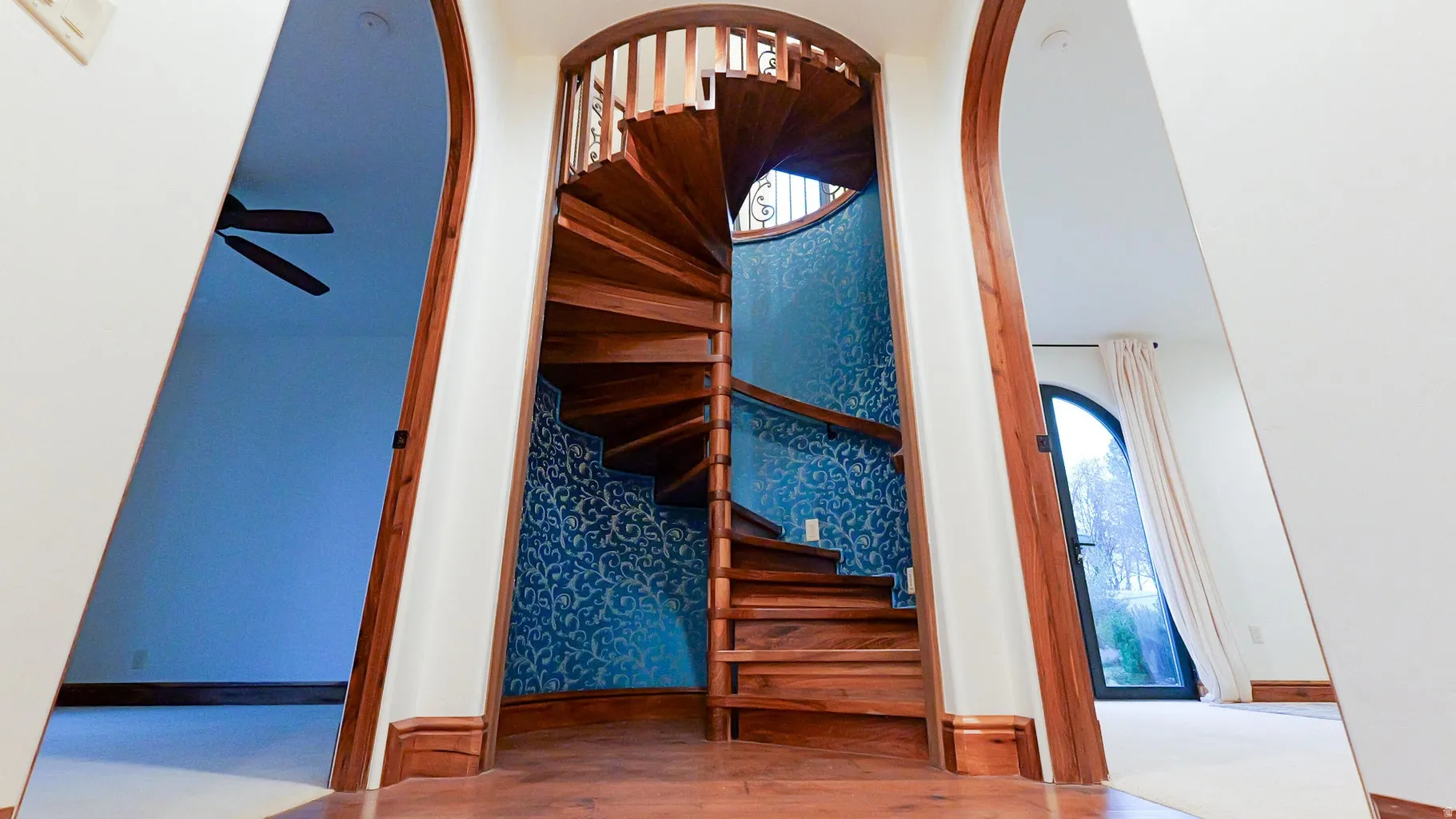 Stairway with arched walkways and wood finished floors