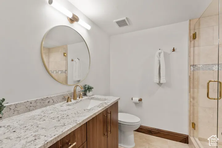 Full bath with a stall shower, vanity, and light tile patterned floors