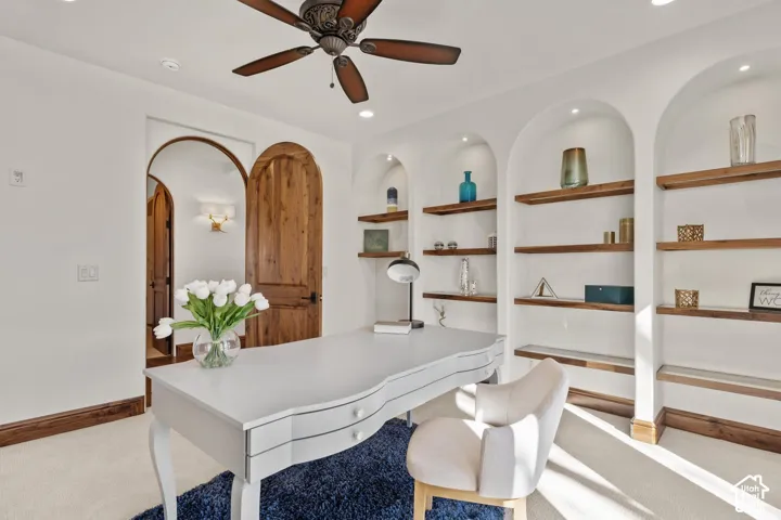 Office area featuring built in shelves, light carpet, ceiling fan, and recessed lighting
