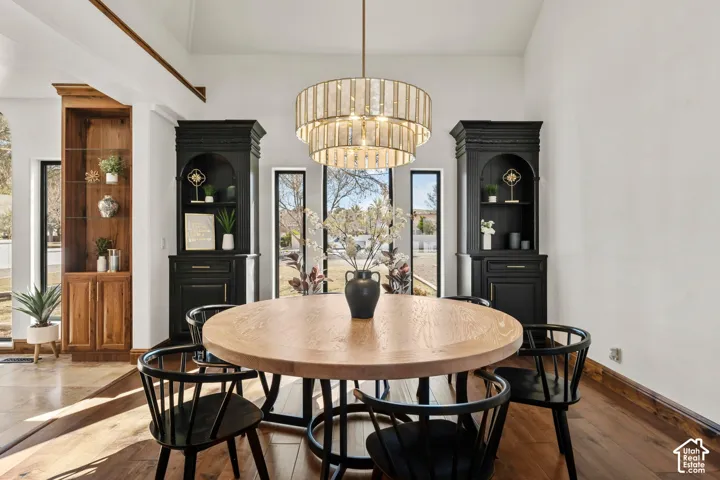 Dining space featuring hardwood / wood-style flooring, hanging lights, and a high ceiling