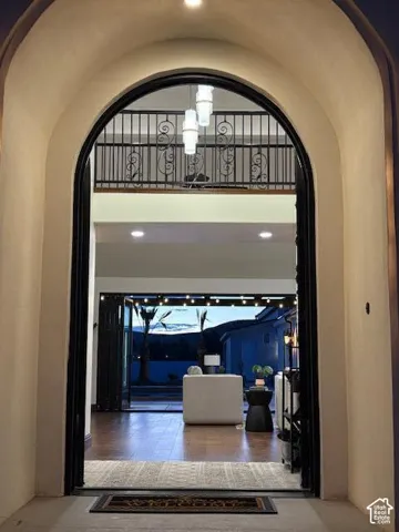 Hall featuring arched walkways, a high ceiling, and recessed lighting