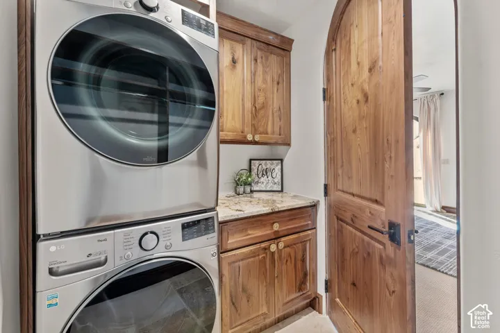 2nd Primary Owner Suite Laundry area with cabinet space and stacked washing machine and dryer