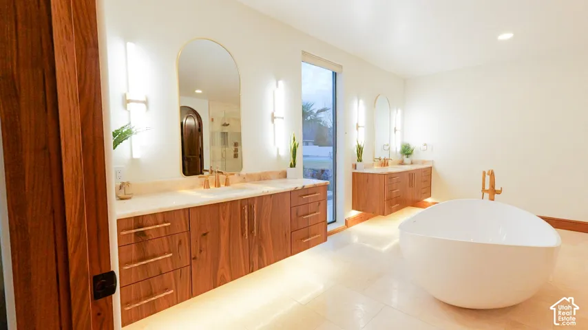 Floating cabinets with two vanities, an enclosed shower, a freestanding bath, and recessed lighting