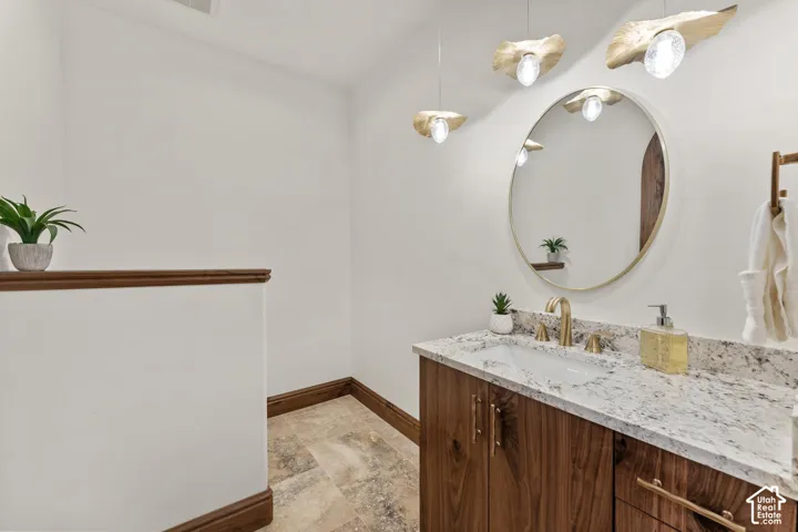 Bathroom featuring vanity and light stone finish floors