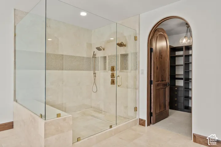 Full bathroom featuring a spacious closet, a shower stall, and recessed lighting