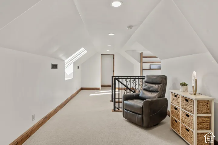 Loft area featuring lofted ceiling, recessed lighting, light carpet, and an upstairs landing