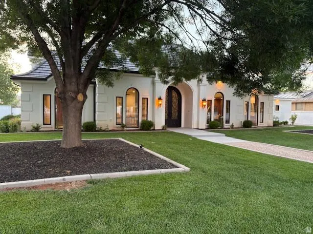 View of front of property with a front lawn and stucco siding