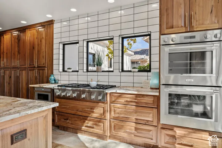 Kitchen featuring stainless steel appliances, light stone counters, wood finish cabinetry, and recessed lighting