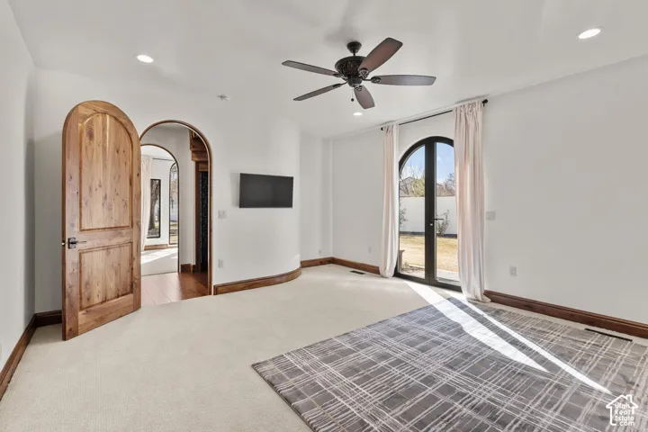2nd Primary Owner Suite with arched walkways, carpet floors, access to exterior, a ceiling fan, and recessed lighting