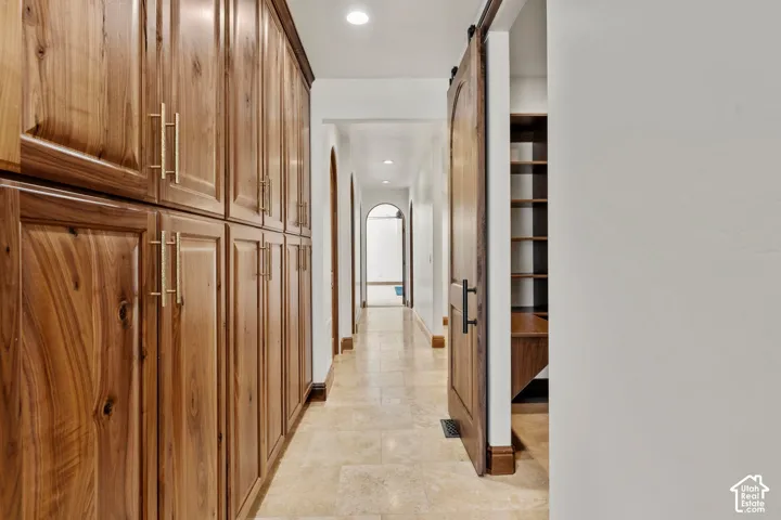 Hall featuring a barn door and tons of cabinets storage space.