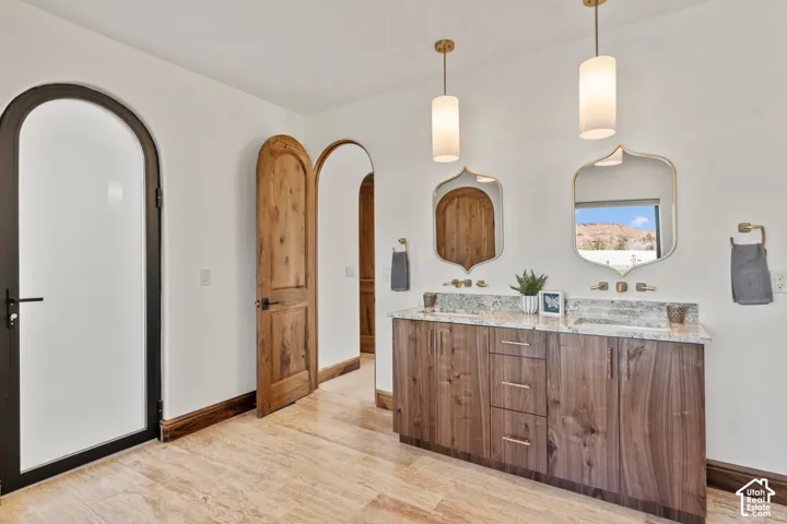 Full bathroom featuring double vanity and light wood-type flooring