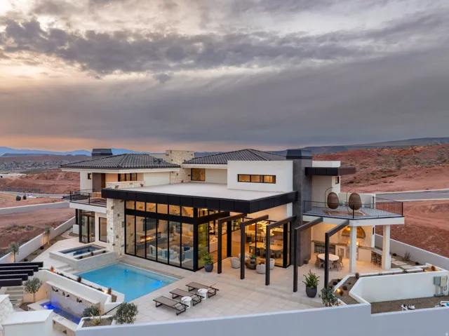 Back of property with a patio, a pool with connected hot tub, and a mountain view