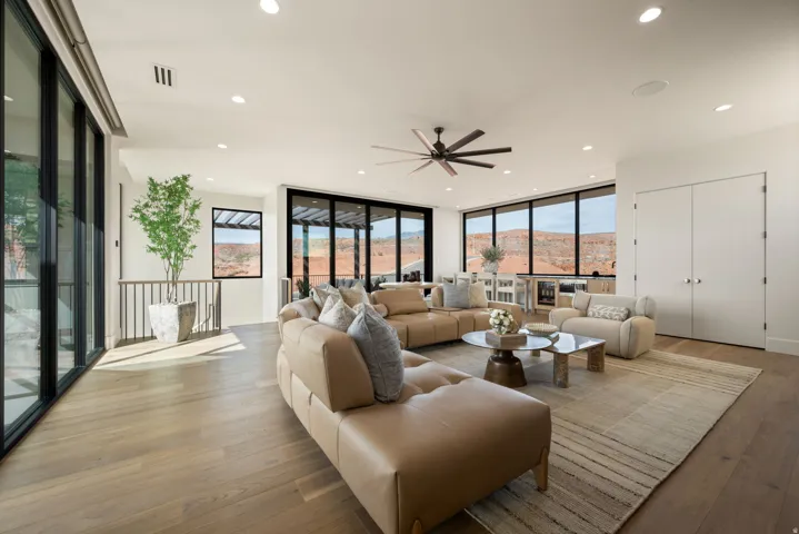 Living area featuring expansive windows, ceiling fan, light wood-style flooring, a mountain view, and recessed lighting