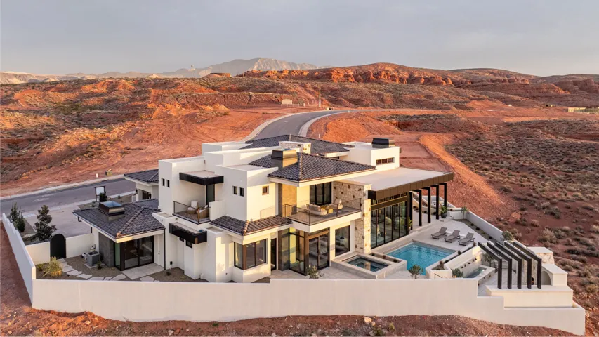 Back of house with a patio area, a fenced backyard, a mountain view, a pool with connected hot tub, and stucco siding
