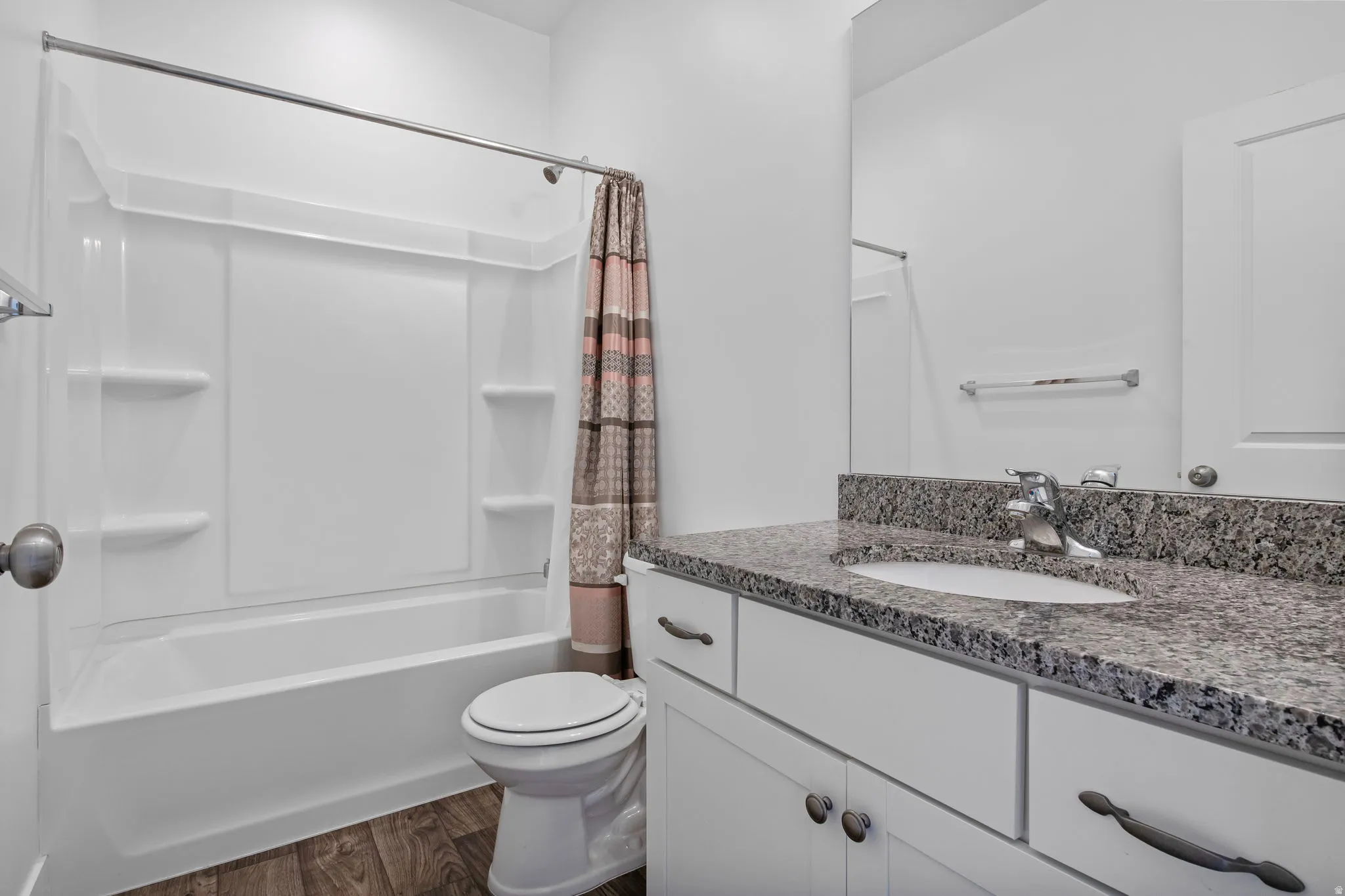 Bathroom featuring shower / bath combo, vanity, and dark wood-style flooring