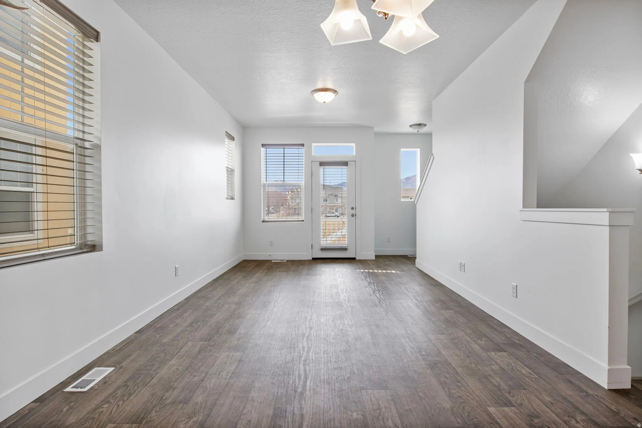 Empty room featuring dark wood-style flooring and a textured ceiling
