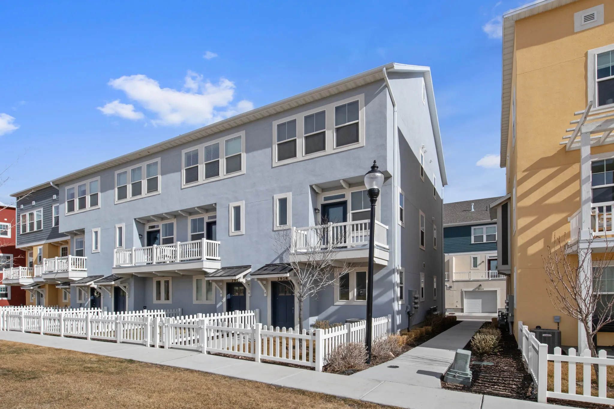 View of front of home featuring stucco siding, a fenced front yard, and a balcony