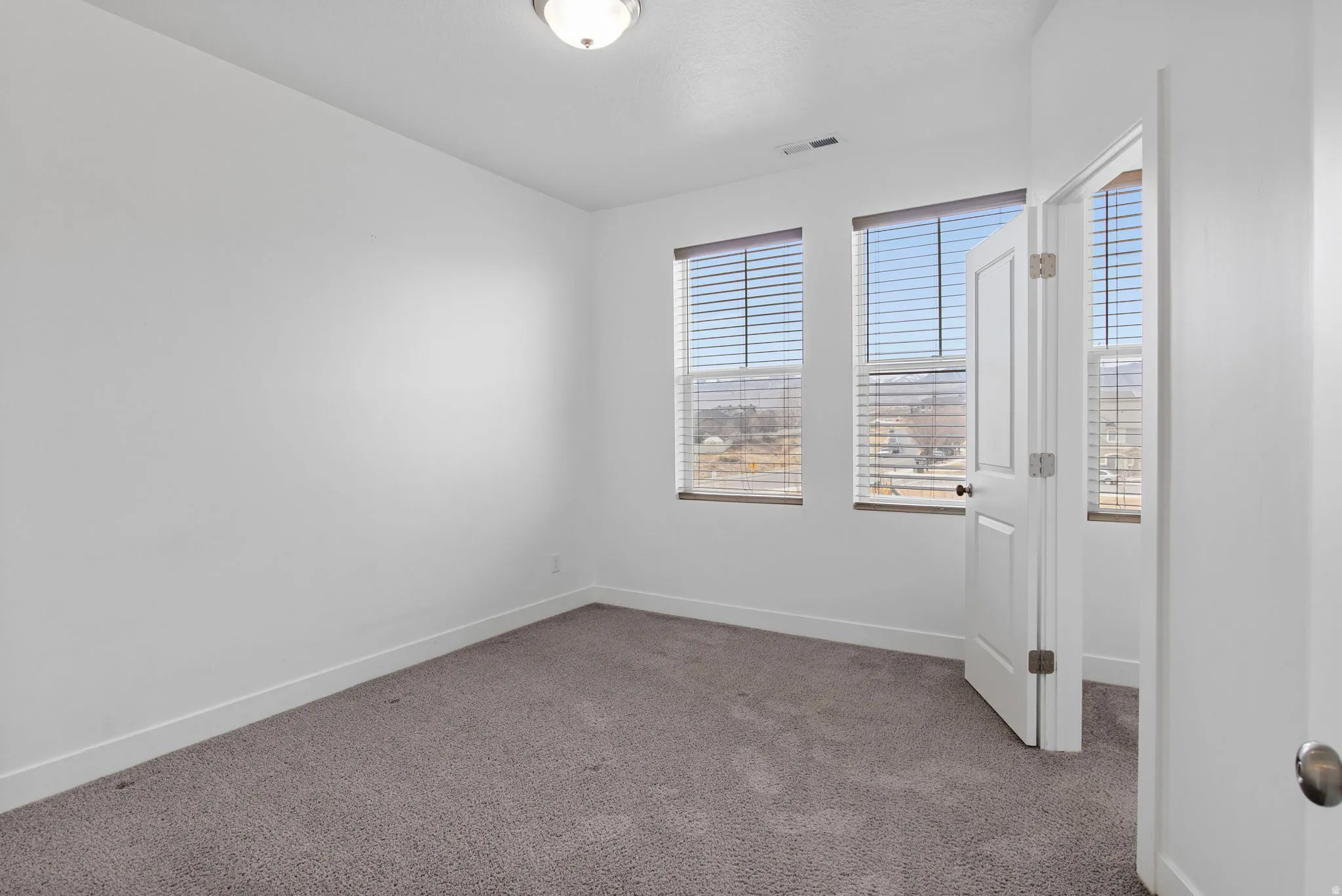 Unfurnished room with baseboards and light carpet
