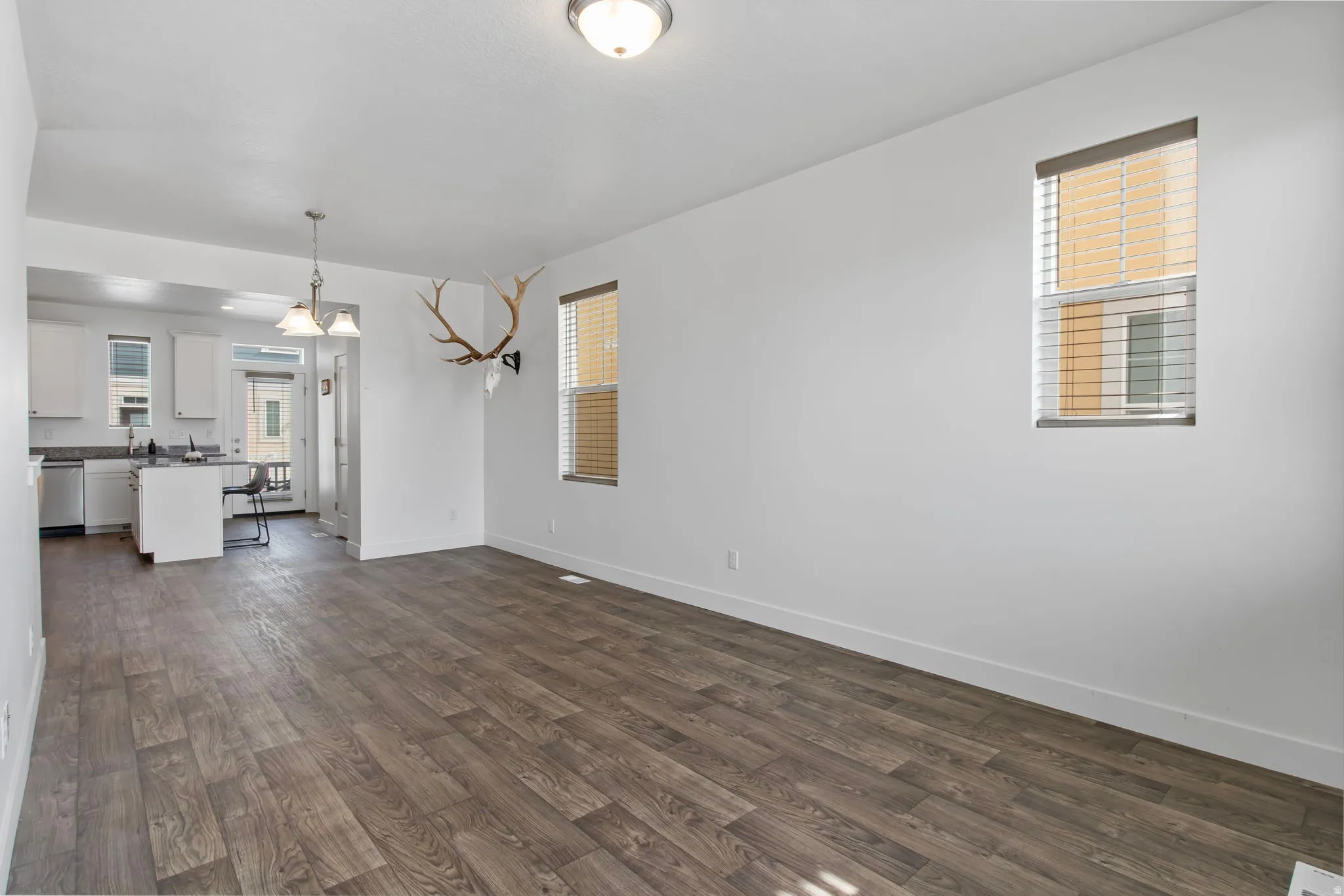 Unfurnished living room featuring dark wood-style floors