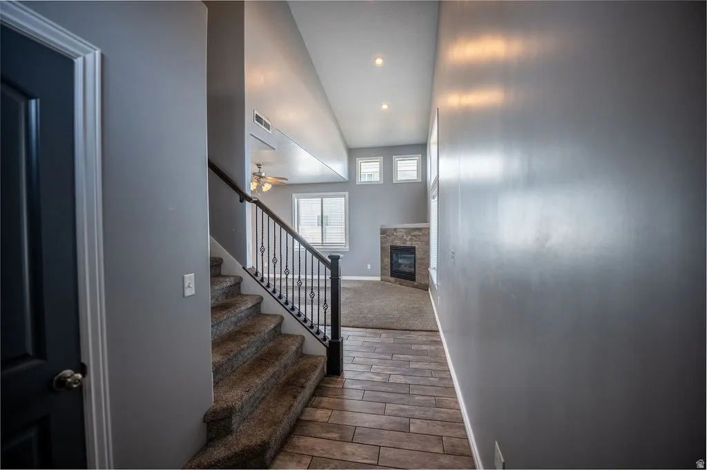 Staircase featuring a fireplace, wood tiled floors, ceiling fan, and recessed lighting