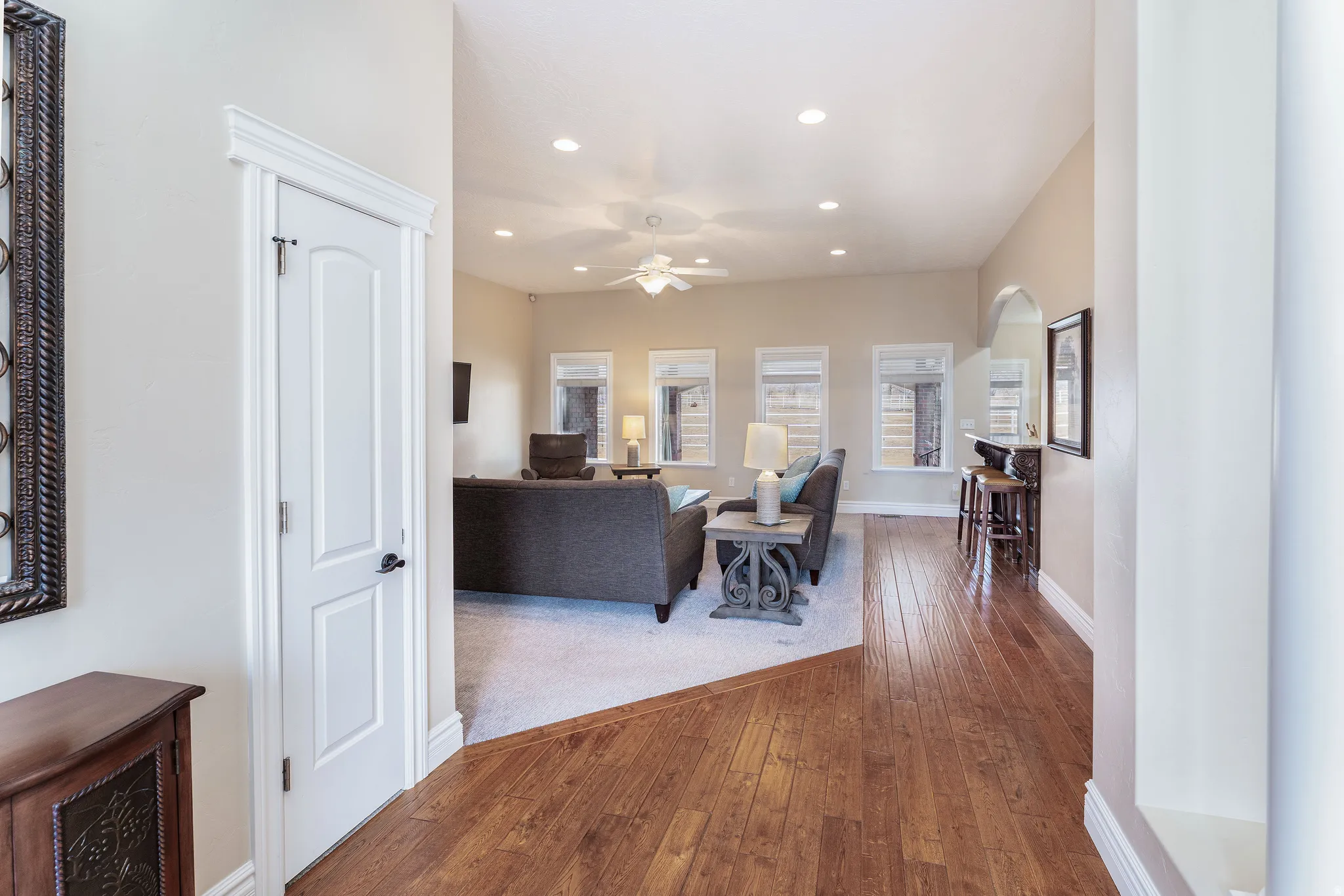 Living area featuring hardwood / wood-style flooring, arched walkways, recessed lighting, and ceiling fan