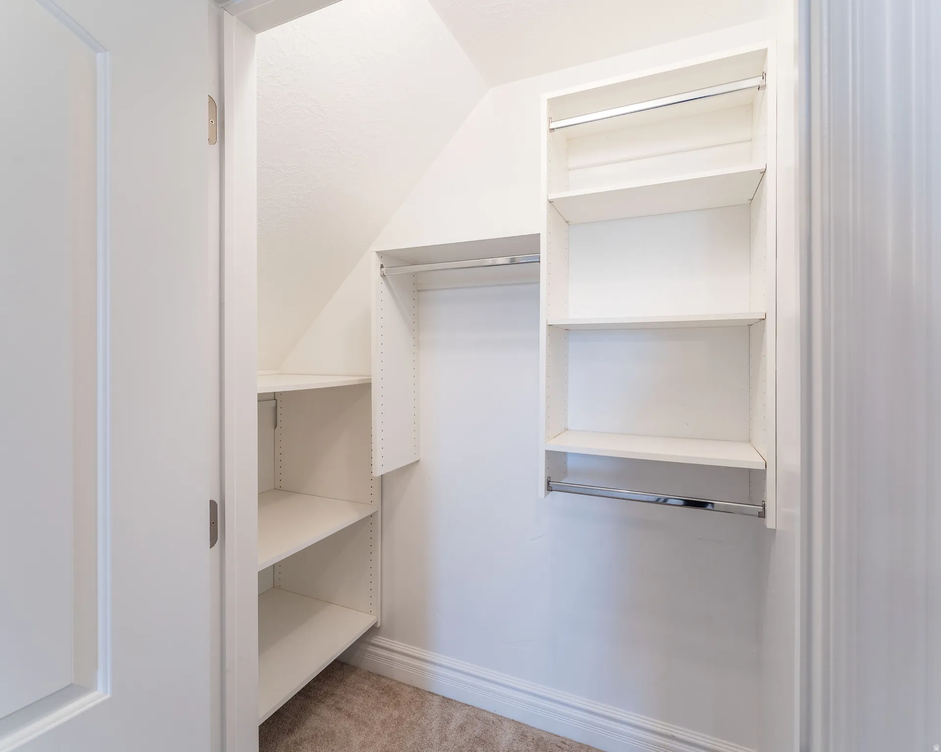 Walk in closet featuring light colored carpet