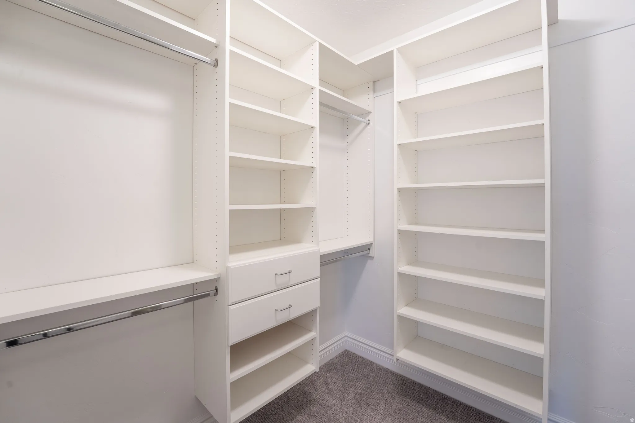 Walk in closet featuring dark carpet