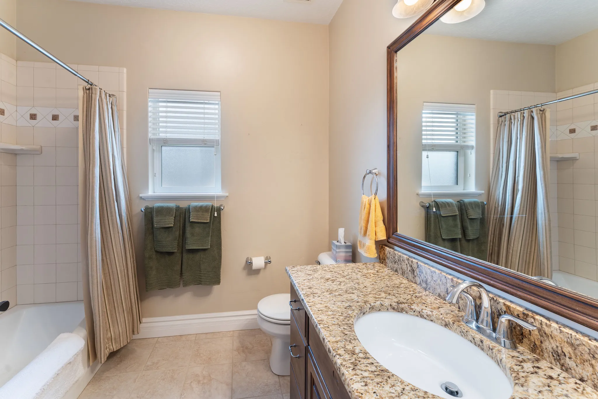 Full bathroom with tiled shower / bath, vanity, and plenty of natural light