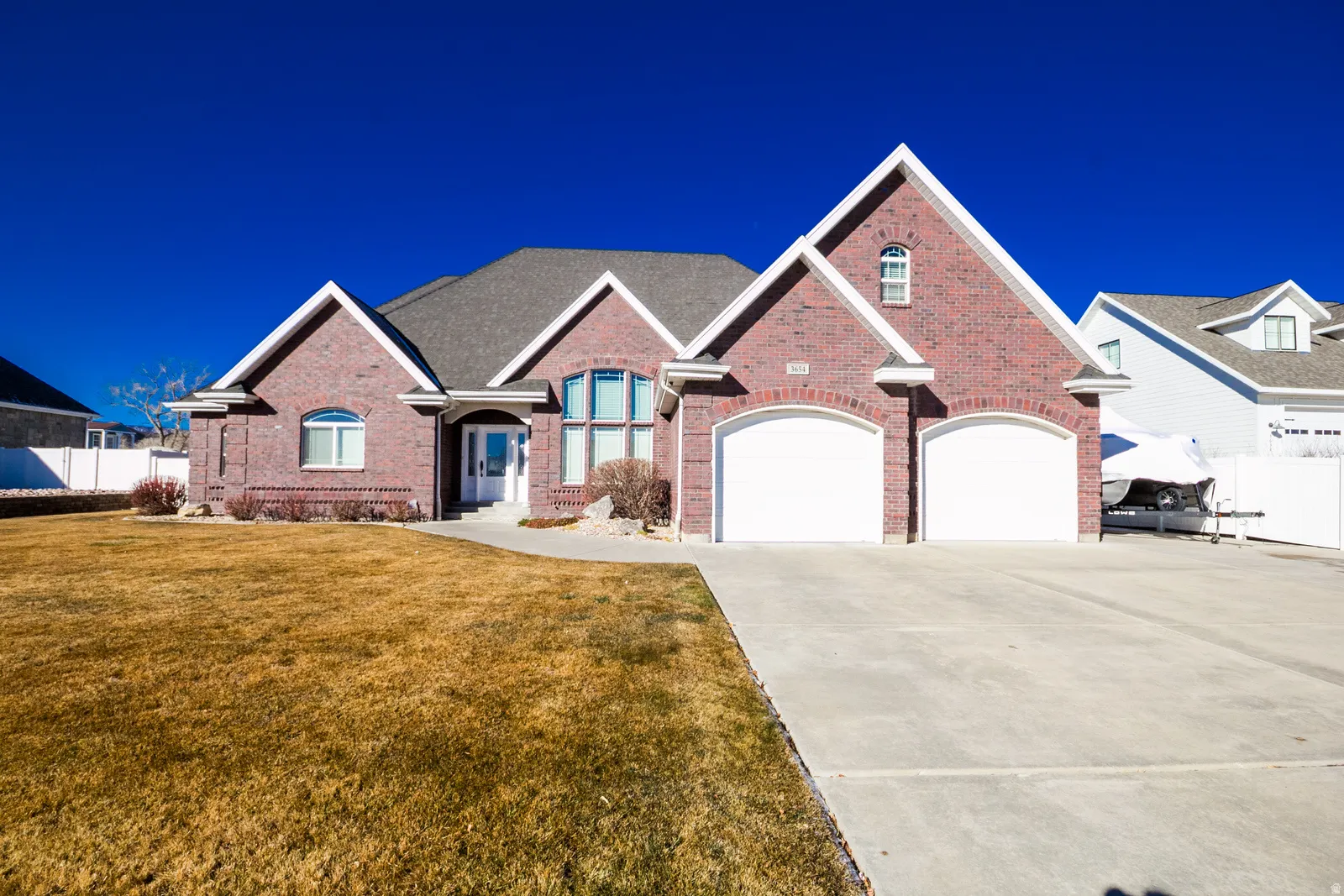 View of front of property featuring brick siding, concrete driveway, and an attached garage