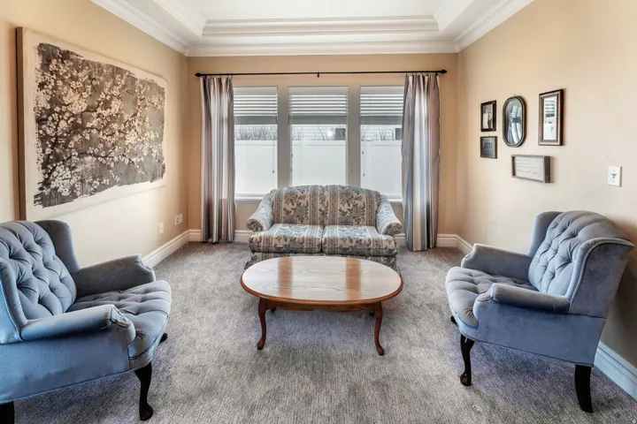 Living area with carpet flooring and crown molding