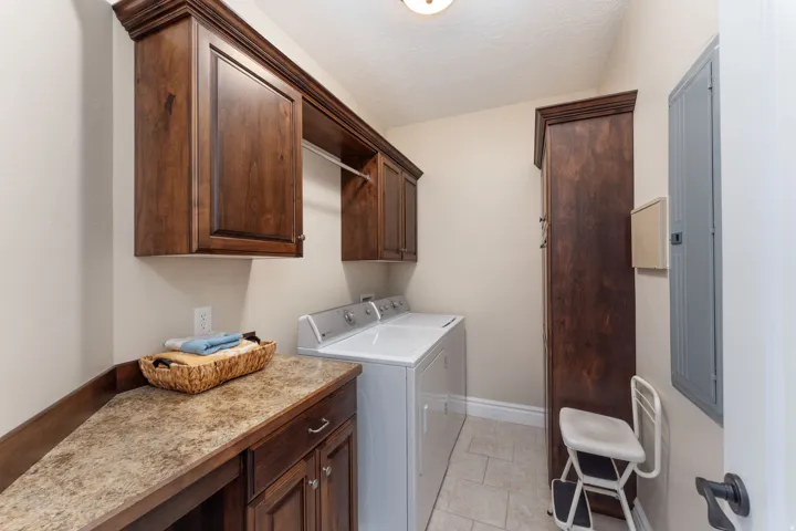 Laundry area featuring cabinet space, washer and dryer, and electric panel