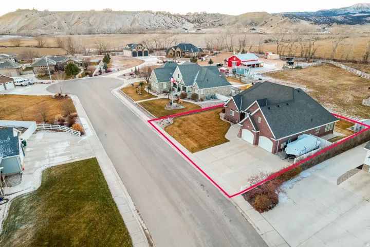 Aerial perspective of suburban area featuring a mountainous background and property parcel outlined